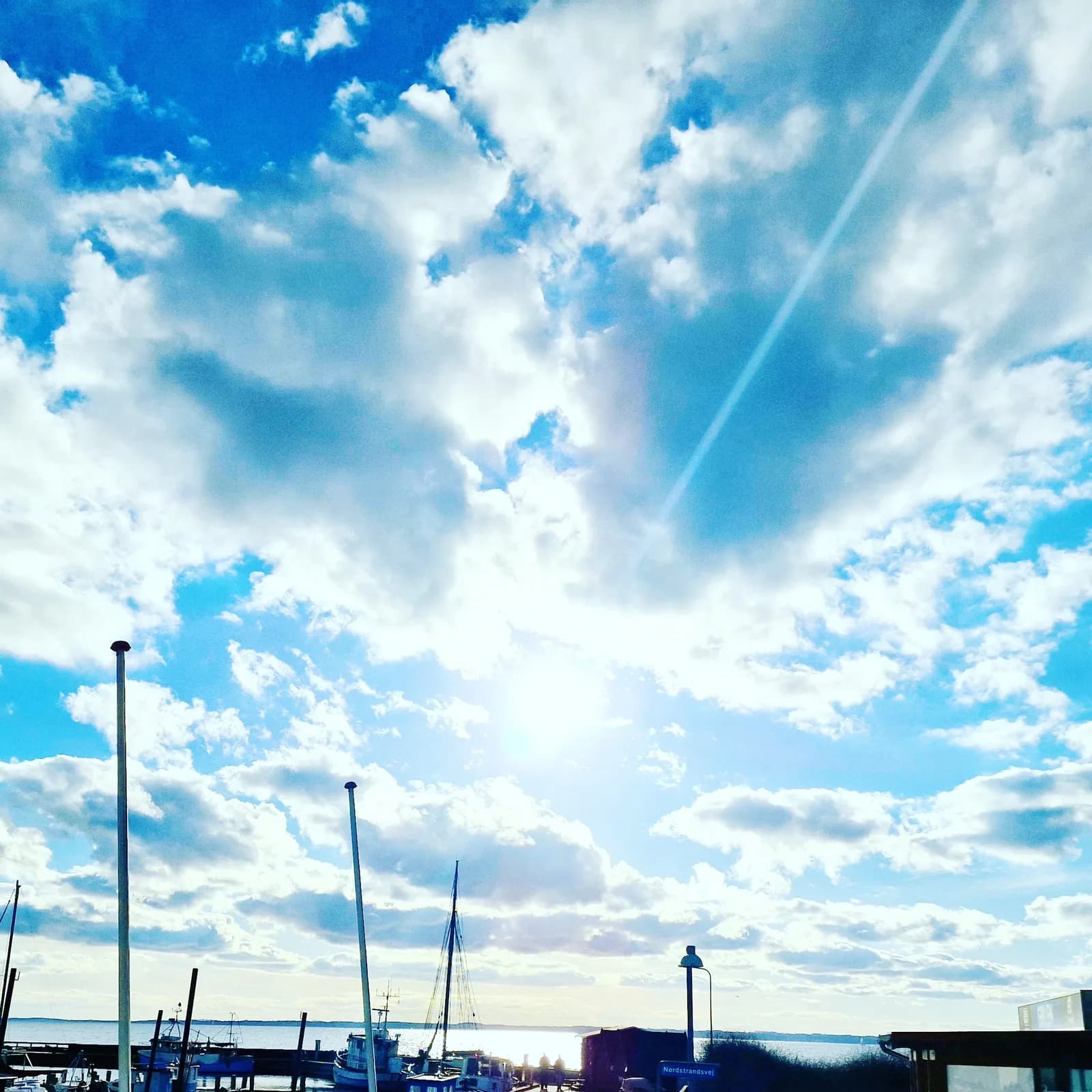 Høj sommerhimmel over lystbådehavnen i Lohals